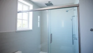Sliding shower door enhancing a modern bathroom's aesthetic with sleek glass and chrome.